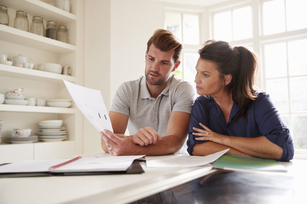Couple Looking At Domestic Finances At Home Together